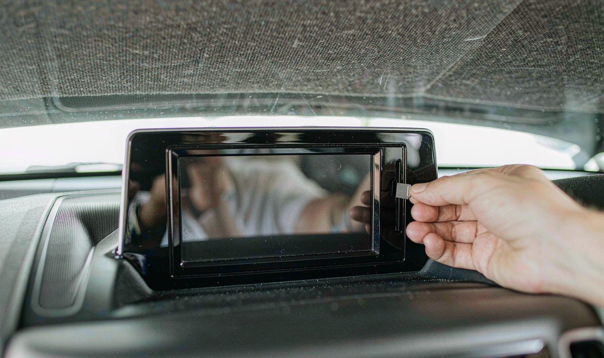 MicroSD card being pushed into the slot beside a car screen android head unit in the dashboard, retrofit car stereo, the removable card path that holds map data