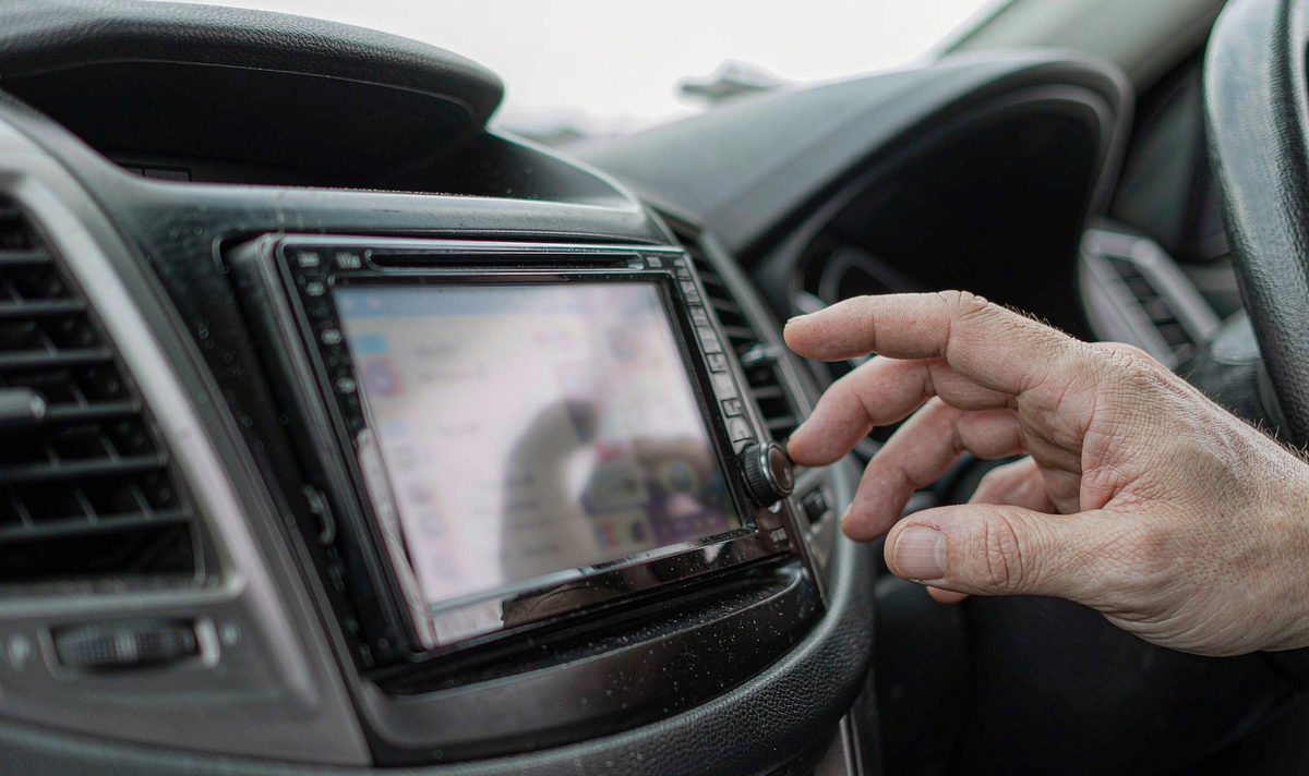 Adjusting text size on an android car stereo head unit aftermarket dash kit, retain original factory features, a hand reaching the screen in the centre console