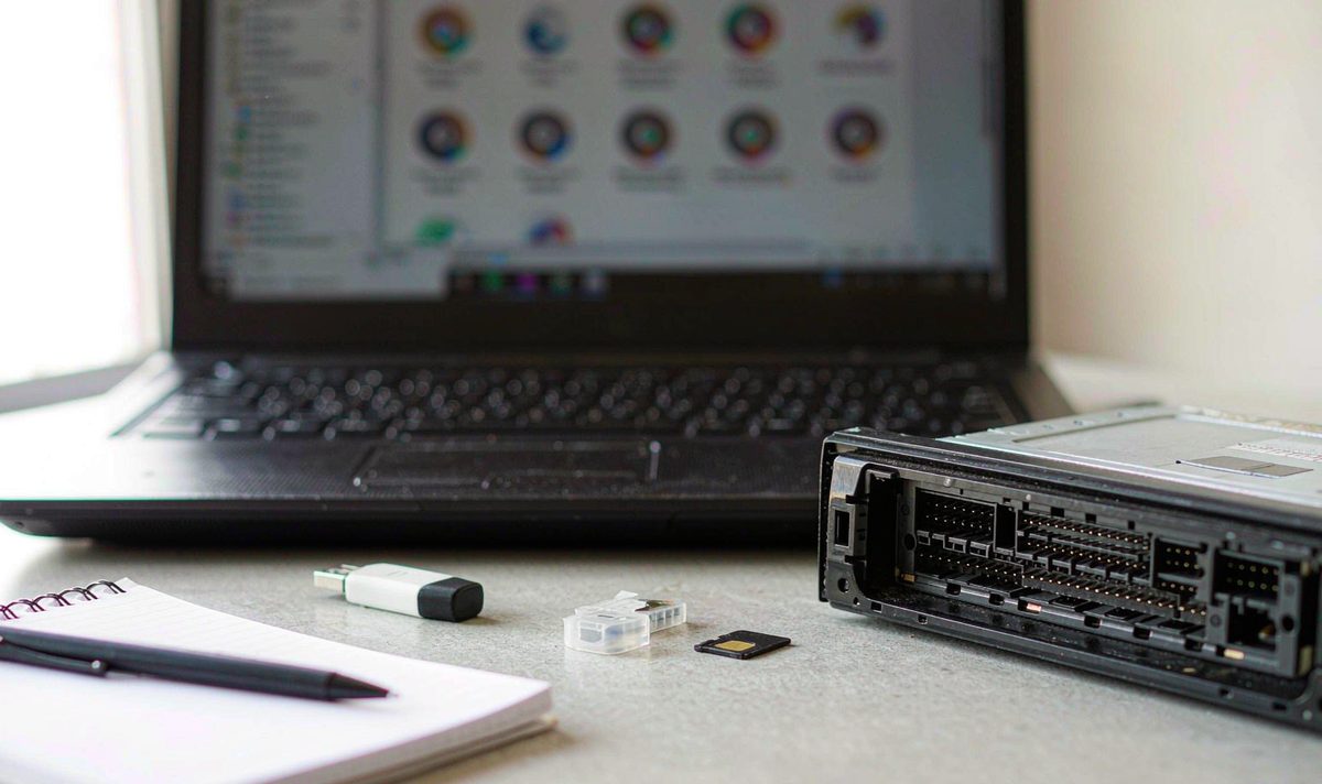 Font files and a backup notebook beside an android head unit rear panel aftermarket dash kit, retain original factory features, with a flash drive and memory card