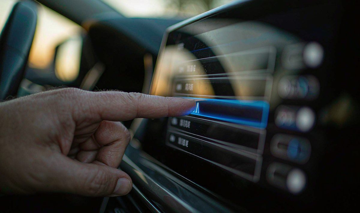Finger tapping one row in a long permission list on a retrofit android car screen at dusk, android head unit settings, checking which apps hold access
