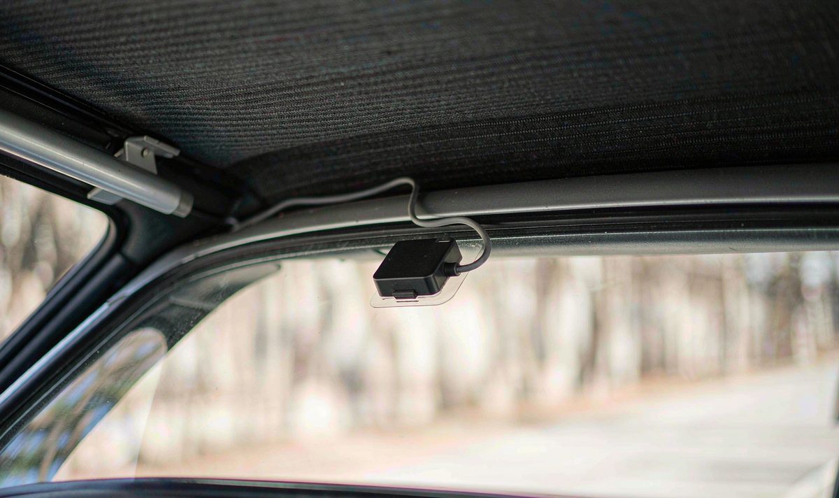 Glass-mounted antennas sit close to the metal roof edge, where the sky view narrows GPS antenna puck bonded to the inside of a windscreen close to the roof lining and A-pillar of a car