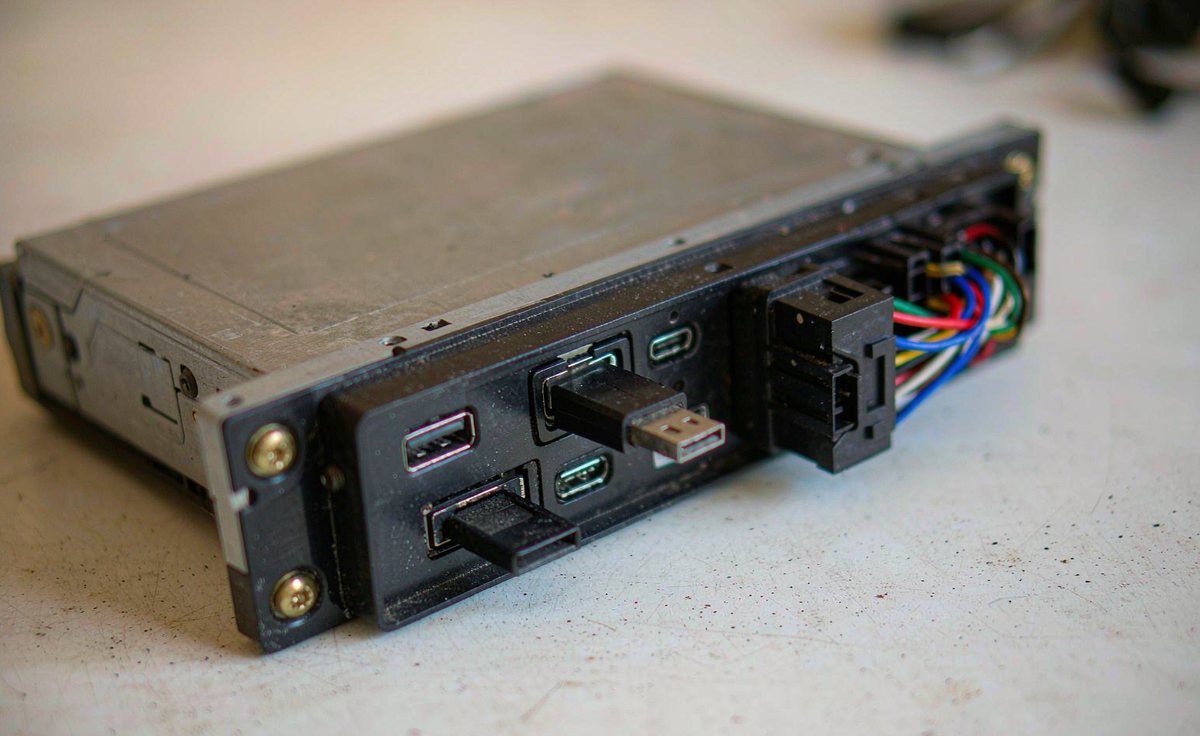 USB drive and memory card in the rear ports of an android car stereo head unit on a workbench