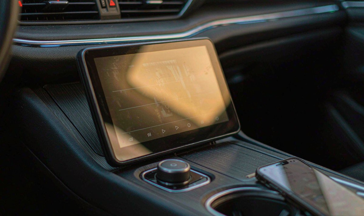A car screen pulling media over Wi-Fi has less margin than a television on the same network Car screen in a centre console playing a film at dusk, a phone resting in the console beside it
