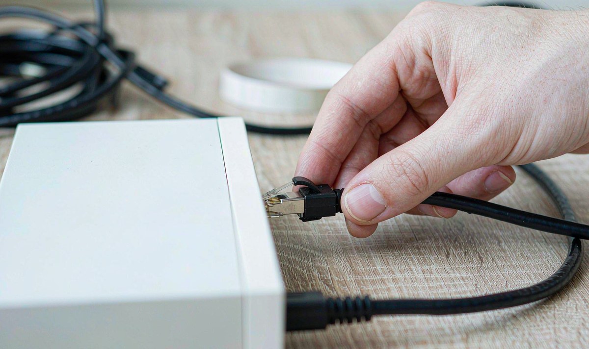 One cable at the source end is the whole link a car head unit gets Close-up of a hand pushing a network cable into a home NAS, the link a car head unit depends on